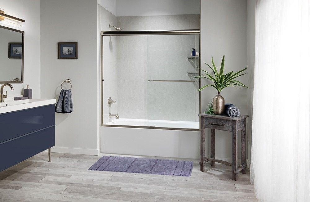 Tub and shower combination with a sliding glass door and navy vanity